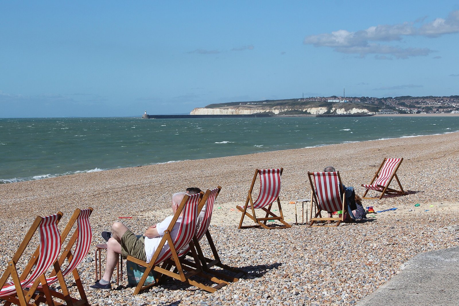 Deck chairs facing the water on a bright day